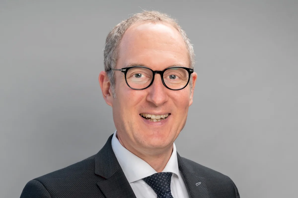 Der Bündner alt Regierungsrat Christian Rathgeb ist seit 2026 Verwaltungsrat der Upgreat AG in Fehraltorf. Porträt von Christian Rathgeb. Er trägt eine schwarze Brille, einen dunklen Anzug mit weissem Hemd und dunkler Krawatte.